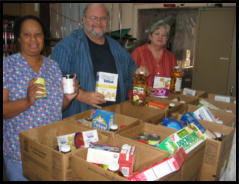 Volunteers help pack the food boxes.